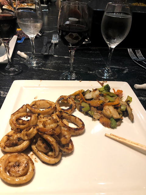 A rectangular dish with teppanyaki style shrimp and squid, accompanied by vegetables