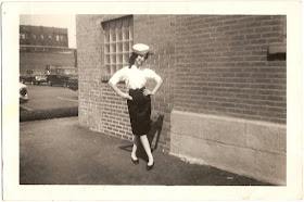 young woman posing in front of brick building with arms on hips with love letter inscribed on reverse from Mary to Harold