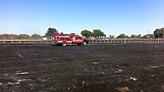 A fire truck in a smoking field after the fire.