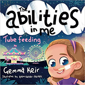 a book called 'the abilities in me: tube feeding'. There is a picture of a girl, blonde and blue eyes, with a nasal feeding tube. She is standing by a fairground, waving and smiling. The Book is written by Gemma Keir, and illustrated by Adam Walker-Parker