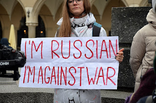 Woman holding hand-printed sign that reads "I'm Russian, I'm against war"