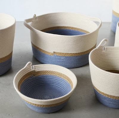 a collection of baskets made of cotton rope and jute; off-white, brown, and blue on the bottom (including the interior)