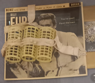 Collage with a Billy Fury single and some plastic hair rollers.