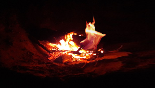 picture of an camp fire a few flames can be interpret as a dancer