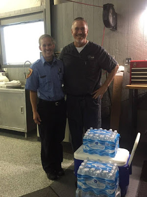 Dr. Kitzmiller stands with a member of the Apex EMS with cooler and water bottles.