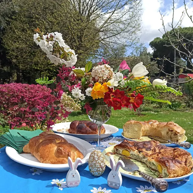 Bellissima tavola apparecchiata all'aperto con fiori brioche salate e  il casatiello.