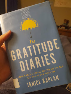 a hand holds the book the Gratitude Diaries