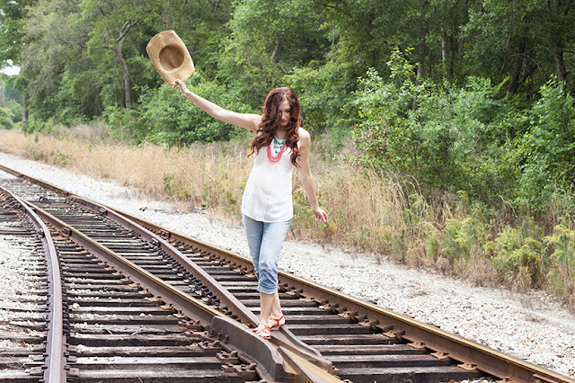 Amy West on rail road tracks with a denim and turquoise maternity inspired look