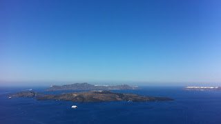 The view of volcano tip out in the center of the caldera from the surrounding cliffs of Santorini.