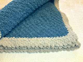 folded blue knitted afghan with gray border