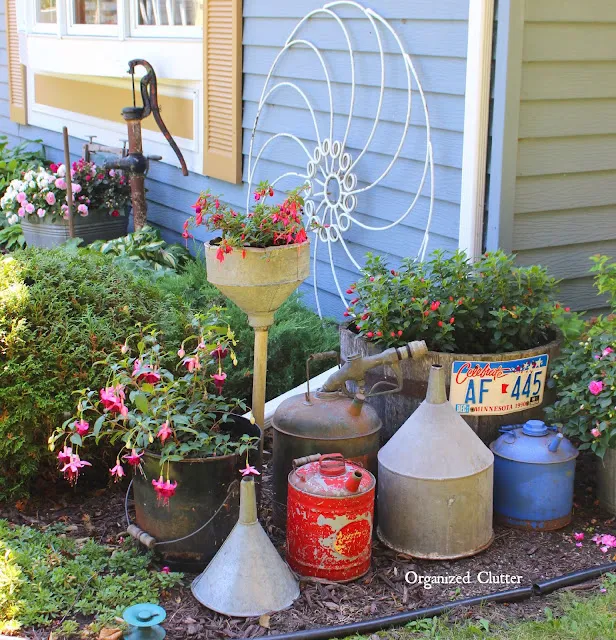 Photo of shade plants and garden junk on the front corner of the house.