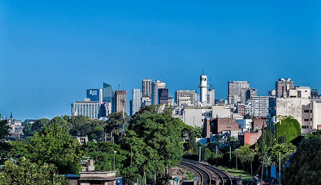 Paisaje urbano de Buenos Aires con vías de ferrocarril y edificios.