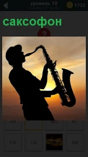 Мужчина играет на закате на саксофоне мелодию. Его силуэт хорошо видно на фоне сумерек