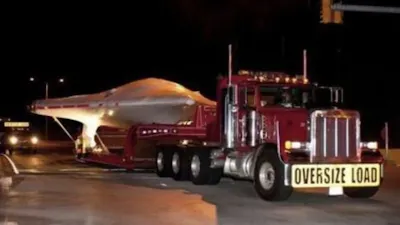 A white Flying Saucer on a low loader flatbed truck.