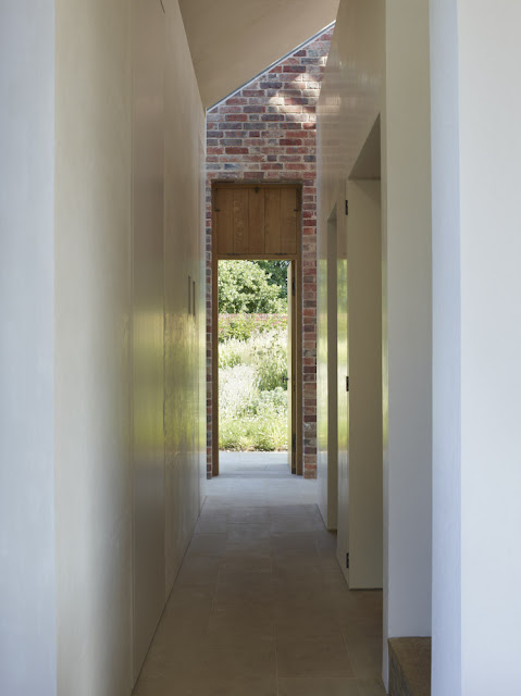 simple white hallway paired with brick and wood