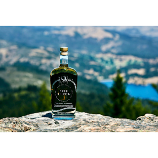 FreeSpirits_bottle_of_non_alcoholic_tequila_perched_on_flat_rock_mountai_top_with_vast_Mexican_landscape_stretching_into_distance_in_hot_weather