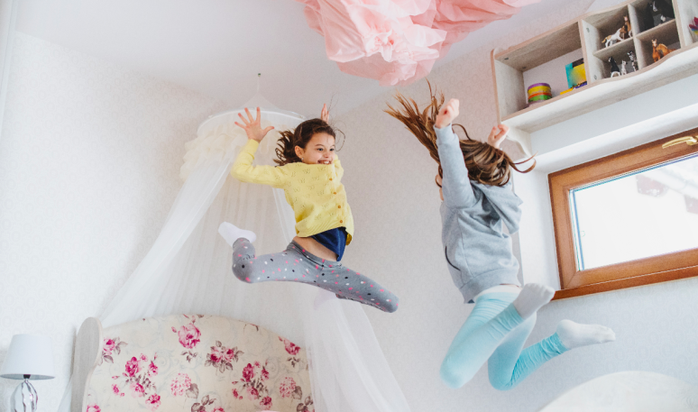 two children jumping on a bed