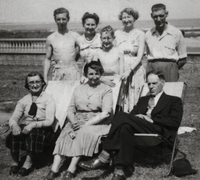 An out door group picture of eight people named in the caption.  Clementina is much older and Peter is a young boy, the ages of the others vary from 45 to late 20s. 