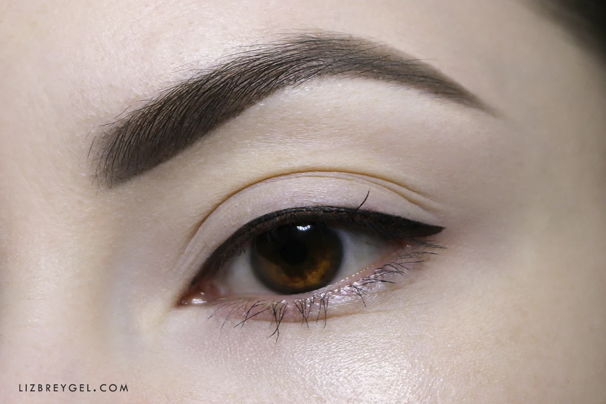 a close-up of an opened woman's eye with a small eyeliner wing