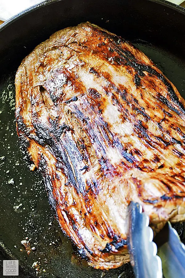 Cast Iron Flank Steak searing in a cast iron skillet on both sides