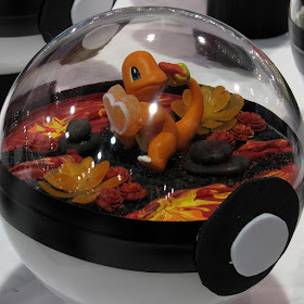 A terrarium with Charmander holding a heart surrounded by lava