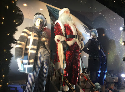 Pic of sequinned Santa coming down steps of jet plane with adult companions