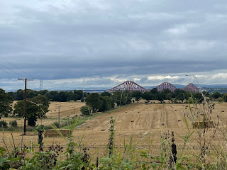A field with the Forth bridges in the distance.
