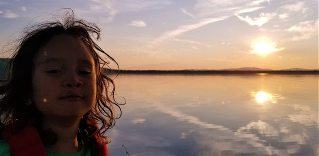 sunset reflection on the water. boy enjoying the weather