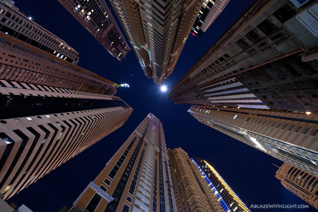 Photo of the skyscrapers in the tallest block of Dubai Marina as seen from the ground looking up at night