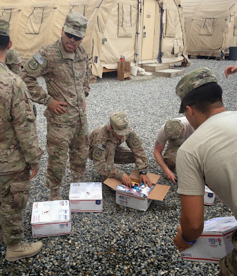 U.S. Soldiers opening up care packages from the Airborne Angel Cadets of Texas.