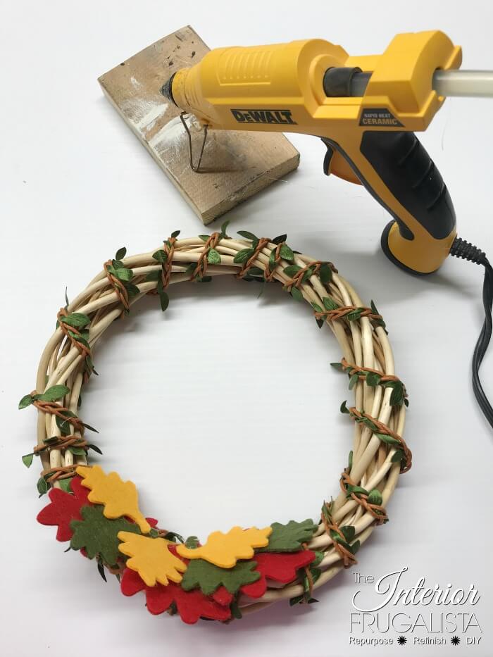 Turn inexpensive dollar store finds into an adorable small DIY Fall Pumpkin Wreath and it's so quick and easy to make in five minutes or less.