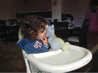 toddler in highchair with teddy bear 