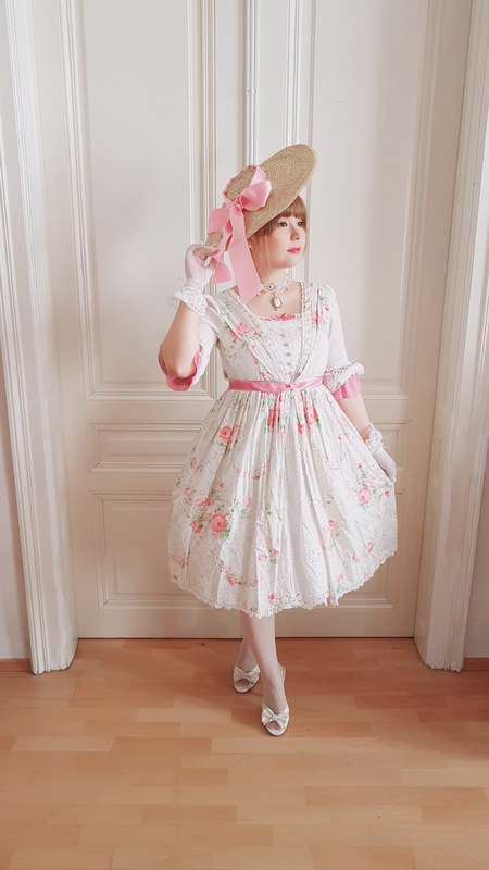 woman wearing a yolanda lolita dress and a bergere hat with a pink ribbon