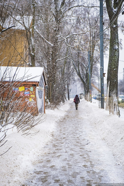 Пешеходная дорожка в снегу и идущая женщина