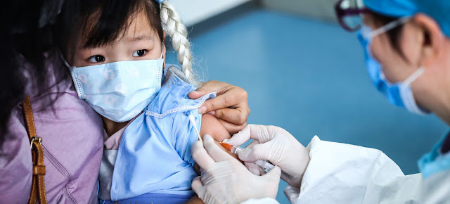 Una niña de 3 años recibe una vacuna en un centro de salud comunitario en Beijing, China.UNICEF/Yuwei