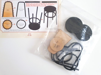 Kit pieces for 2 one-twelfth scale miniature bar stools with the instructions to put them together,