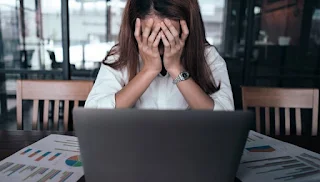 Woman leaning over computer in worry