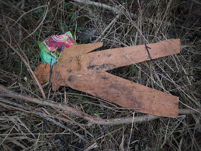 Platte mensenfiguur van hout, ongeveer levensgroot, in het struikgewas