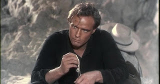 Fotograma en que se ve completamente el collar en las manos de Marlon Brando - El rostro impenetrable