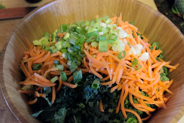 2/3 of the green onions being added to the salad bowl.