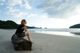 Woman sitting on a rock by the beach