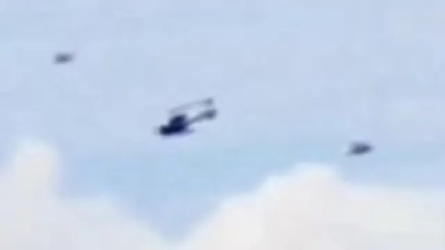 Helicopter with 2 UFOs flying next to it.