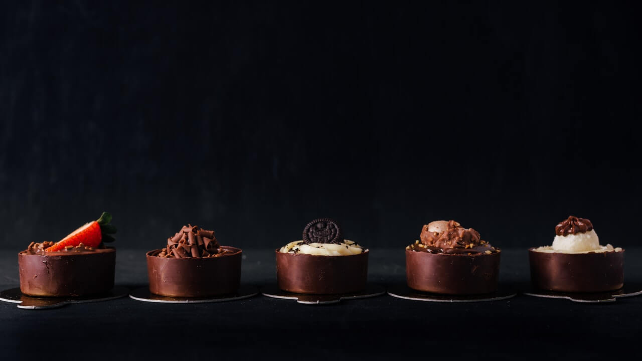 5 chocolate cakes aligned black background | 10 Product Photography Tips