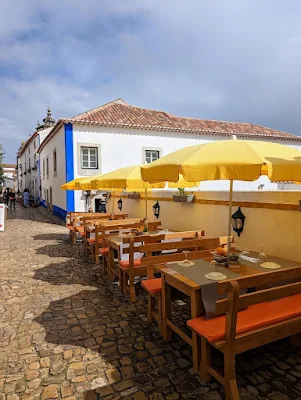 Benches with yellow umbrellas outside Lounge in Obidos