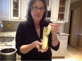 woman holding a peeled plantain in her kitchen