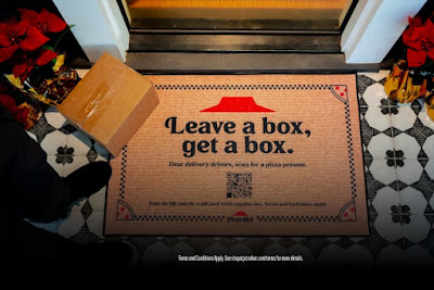Pizza Hut "Reverse Delivery" doormat with a package held over it.