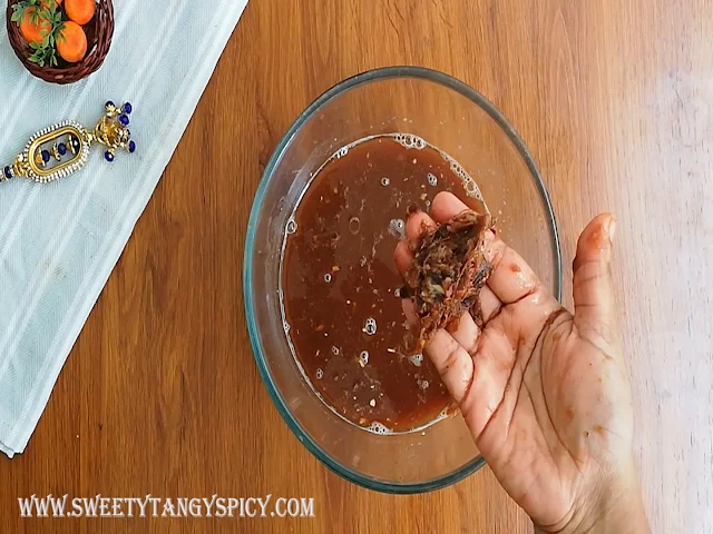 amarind juice being squeezed from the soaked tamarind, ready to infuse tangy flavors into the Inji Puli chutney.