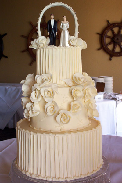 Elegant three tier round wedding cake with sugar roses emphasizing the