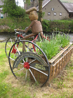 Figure on a tricycle planter advertising local bike shop, Beddgelert, Wales