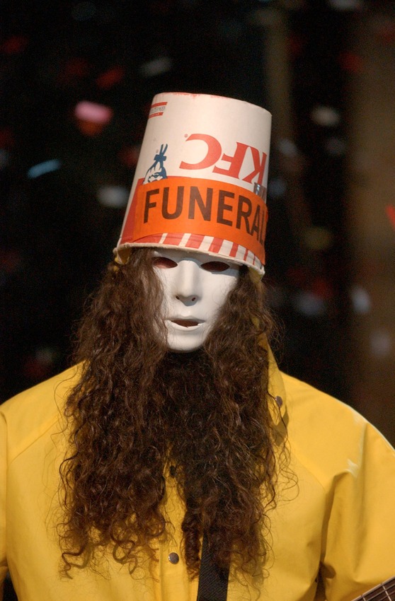 Buckethead trademark look: a KFC bucket, a Michael Myers Halloween mask, a yellow raincoat.